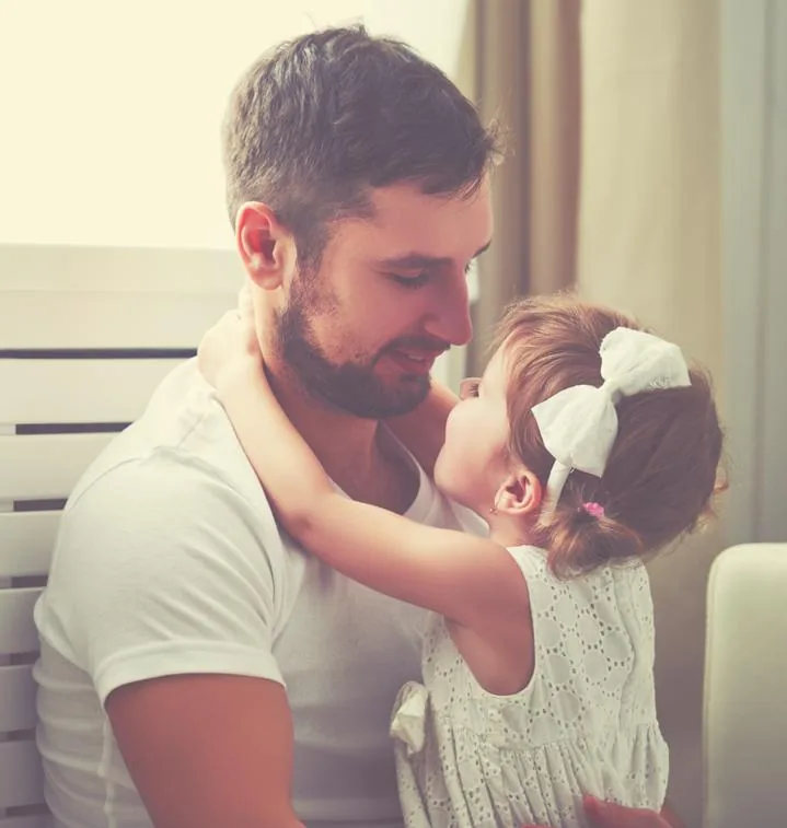 A father holding his young daughter